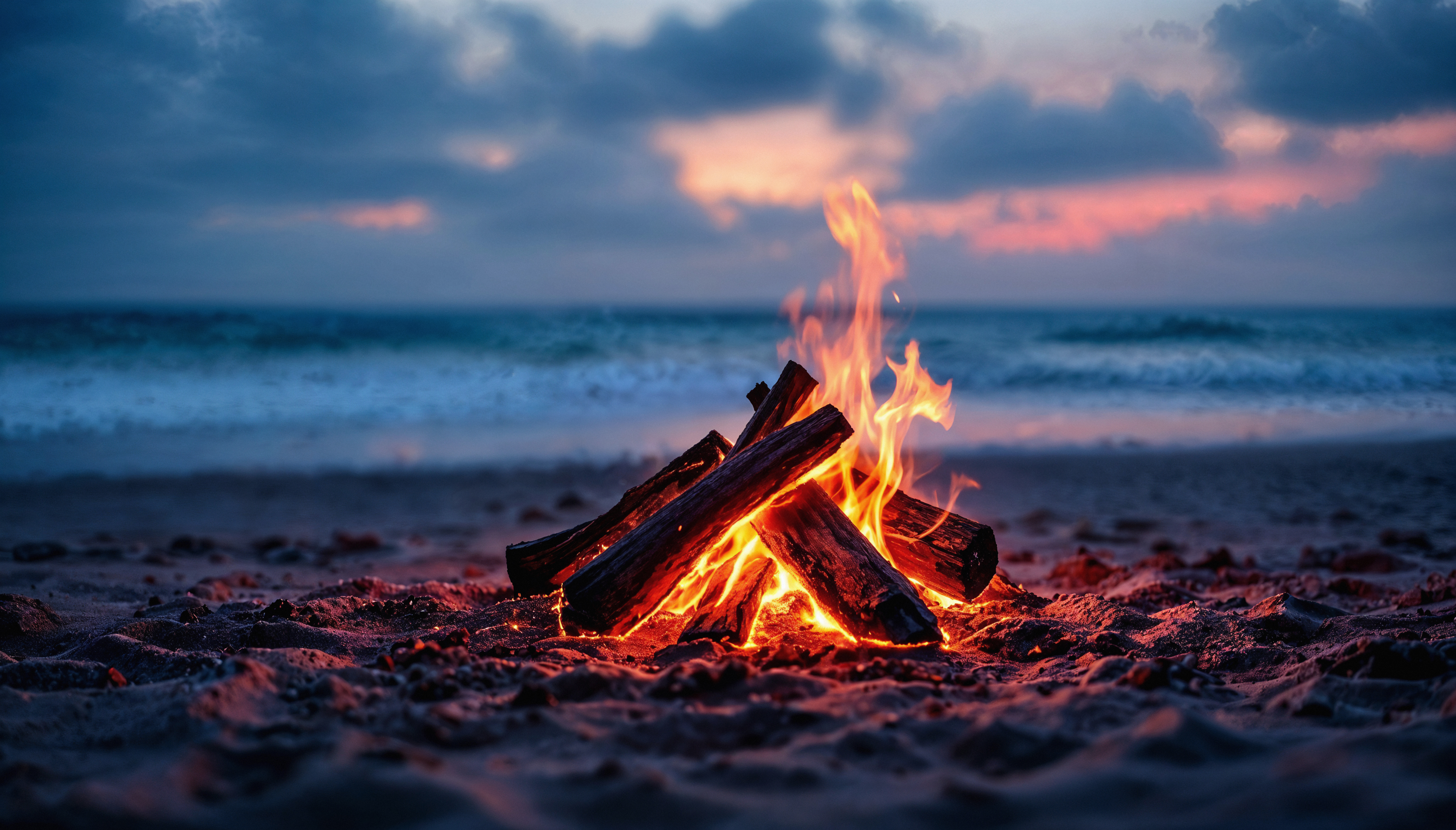 Friends laughing around a beach bonfire at night